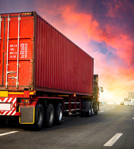 image motion blur.Truck on highway road with red container, transportation concept.,import,export logistic industrial Transporting Land transport on the asphalt expressway with sunrise sky.